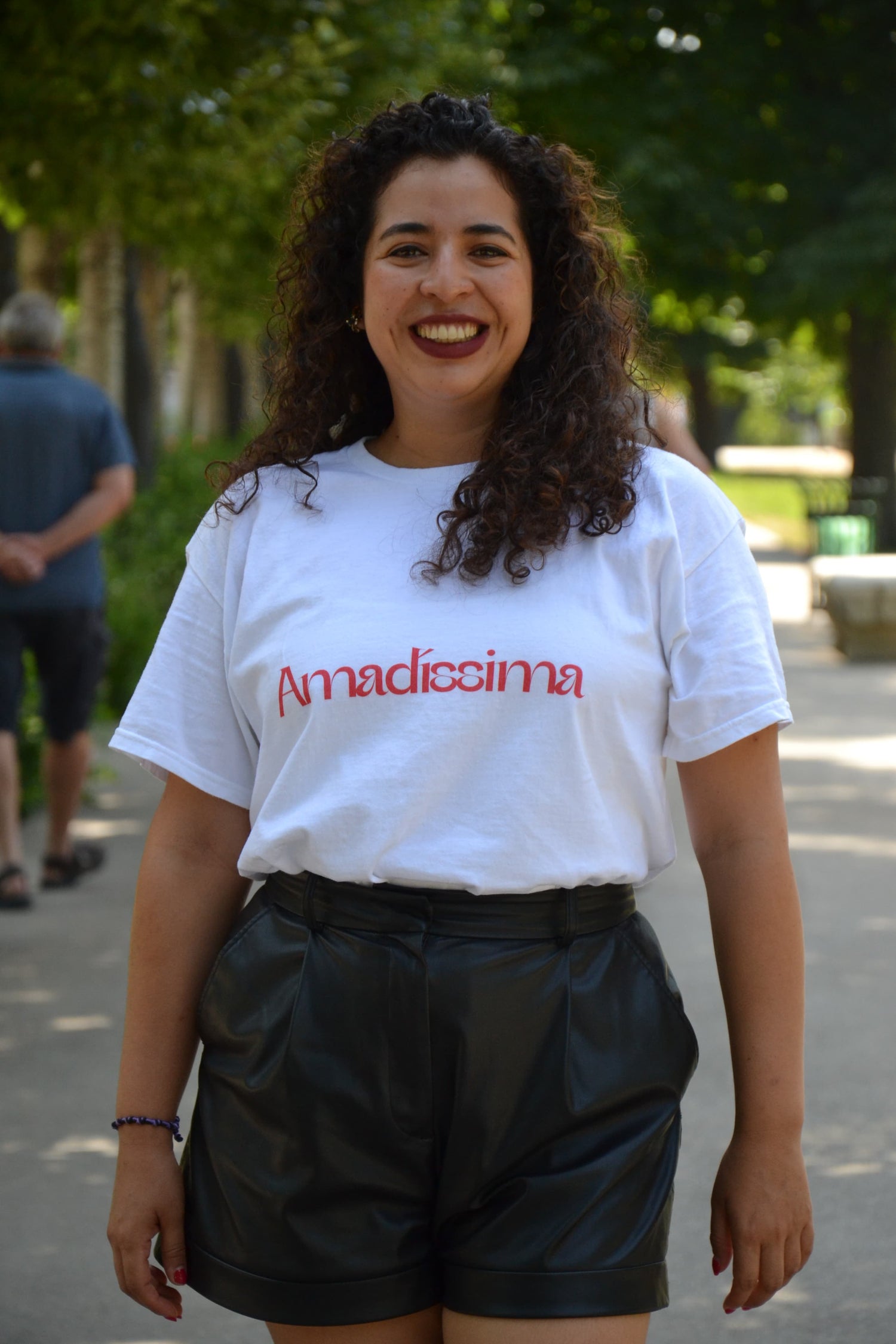 Mujer con camiseta blanca Amadíssima en rojo, recordando su poder interior con suavidad.