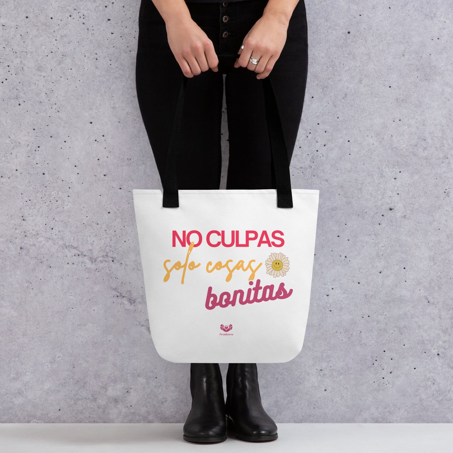 Bolsa tote “No culpas, solo cosas bonitas” con asas negras, vista frontal con manos sosteniéndola