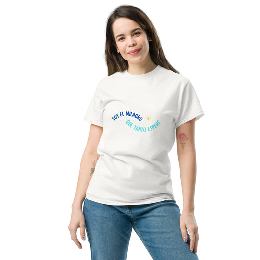 Mujer vistiendo camiseta blanca “Soy el milagro que tanto esperé” en ambiente luminoso y relajado