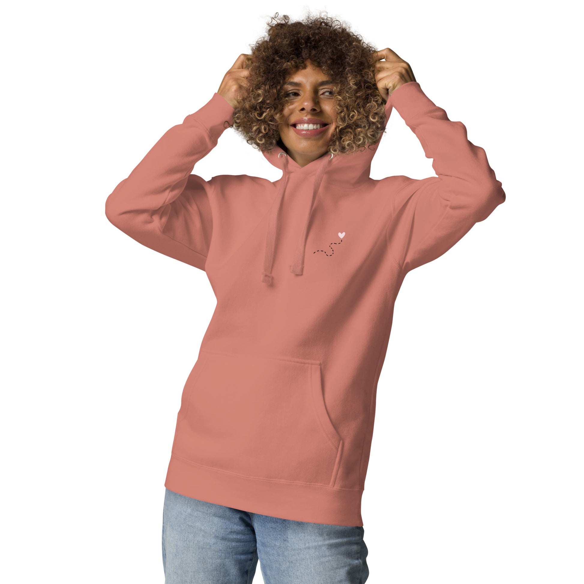 Mujer con sudadera dusty rose y capucha puesta, mensaje “Si me pierdo el camino, soy yo”